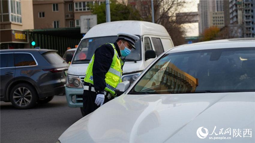 執勤交警為群眾講解防疫政策。